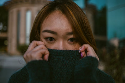 Portrait of beautiful woman with hand in background during winter