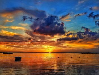 Scenic view of sea against dramatic sky during sunset