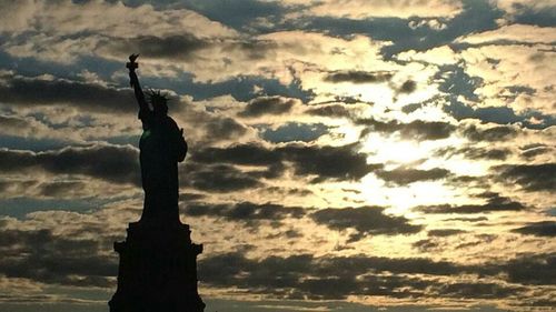 Silhouette of statue against cloudy sky