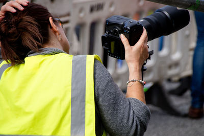 Rear view of woman photographing through camera