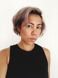 Close-up portrait of young woman against white background