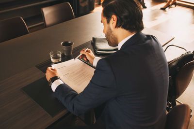 High angle view of male lawyer reviewing documents at table in law office