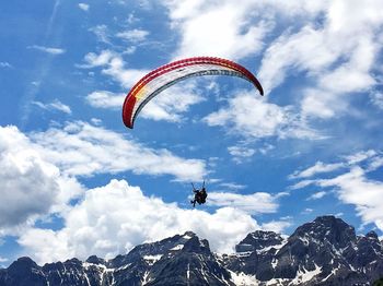 Low angle view of person paragliding against sky