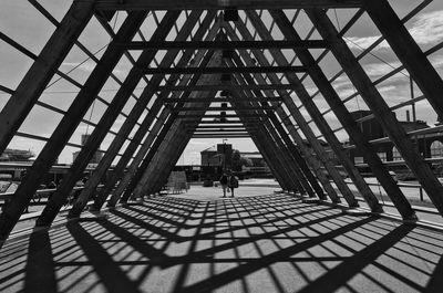 Shadow of metallic built structure falling on footpath in city