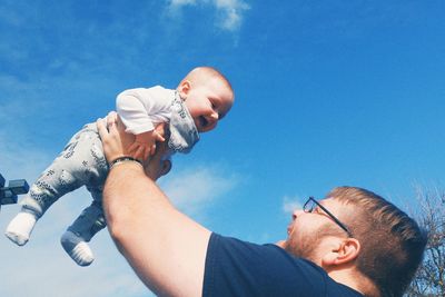 Portrait of father with son against sky