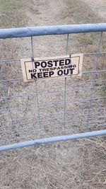 High angle view of warning sign on metal fence