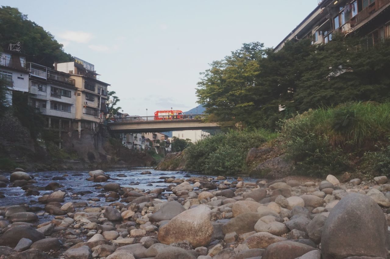 VIEW OF ROCKS BY WATER AGAINST SKY