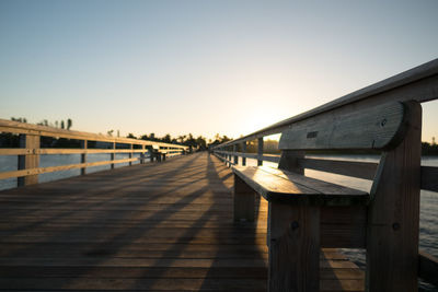 Empty pier against clear sky during sunset