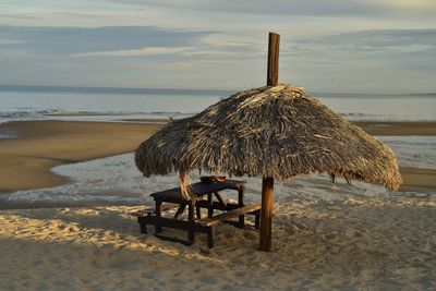  palm thatched beach umbrella  sea of cortez at low tide, san felipe, baja, mexico