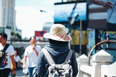 Rear view of people sitting on street in city