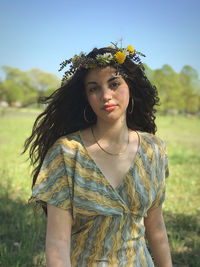 Portrait of young woman standing against plants