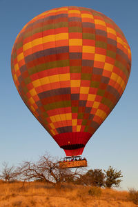 Low angle view of hot air balloon flying over field