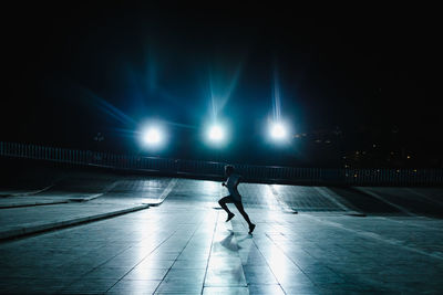 Woman walking on footpath at night