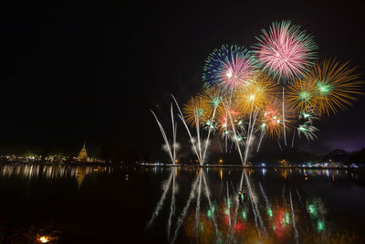 Firework display over lake at night