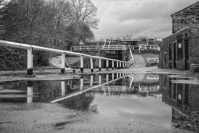 Bridge over river against cloudy sky