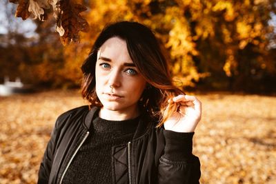 Portrait of beautiful young woman standing during autumn