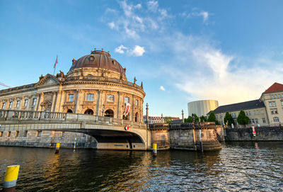 Arch bridge over river against buildings in city