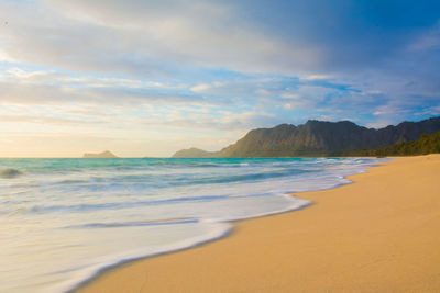 Scenic view of waimanalo beach with mountains at sunrise 