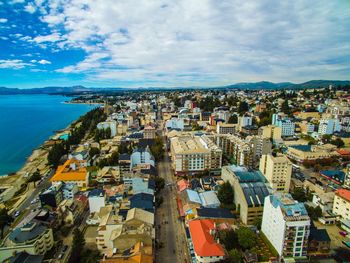 High angle view of townscape by sea against sky