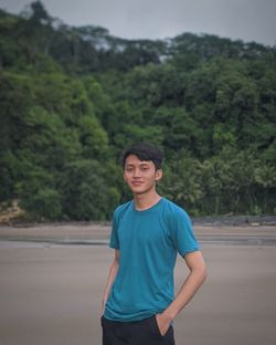 Portrait of young man standing on beach