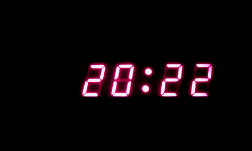 Close-up of illuminated clock in darkroom