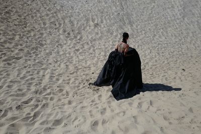Rear view of woman standing at beach