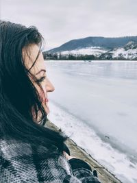 Woman at lakeshore during winter
