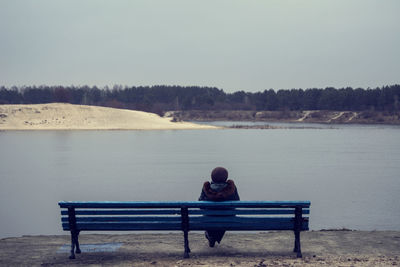 People sitting on bench at seaside