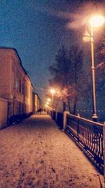 Illuminated street light against sky at night during winter