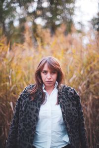 Portrait of young woman standing in forest