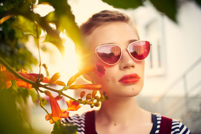 Close-up portrait of young woman wearing sunglasses