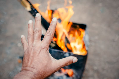 Cropped image of hand against orange wood