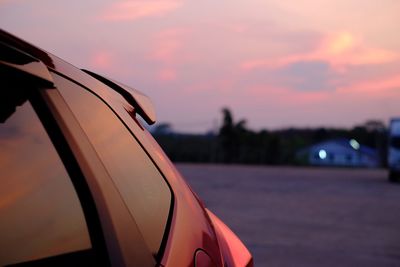 Close-up of car against sky at sunset