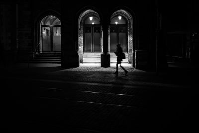 Rear view of silhouette man walking in illuminated building