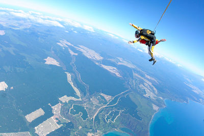 People skydiving over landscape