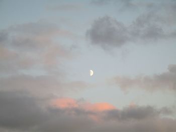 Low angle view of moon in sky at sunset