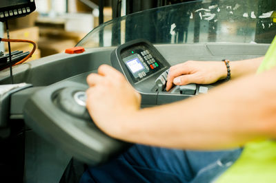 Cropped image of worker driving forklift in factory