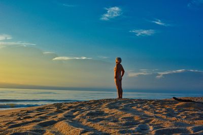 Full length of man standing on beach against sky