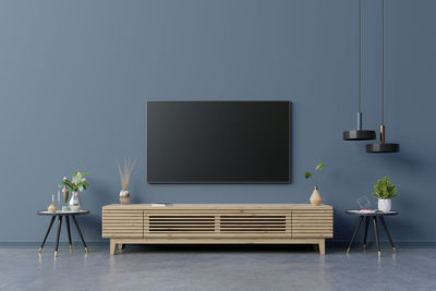 Led tv on the dark blue wall in living room,minimal design.3d rendering