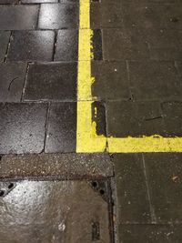 Full frame shot of wet yellow road