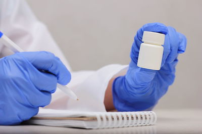 Cropped hand of dentist examining chemical in laboratory