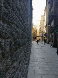 People walking on footpath amidst buildings in city