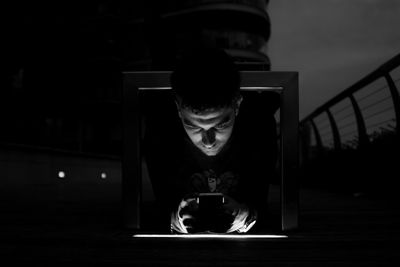 Man using mobile phone while sitting in kitchen