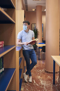 Full length of young man sitting on table