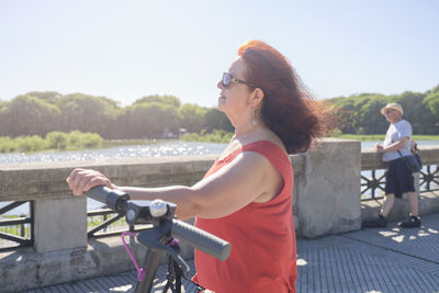 Side view of woman using mobile phone in city