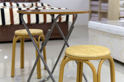 Close-up of empty stools and wooden table