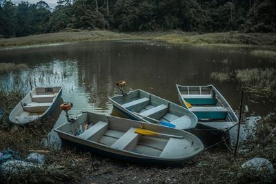 Boats moored at lakeshore against sky