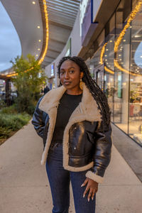 Portrait of young woman standing on street