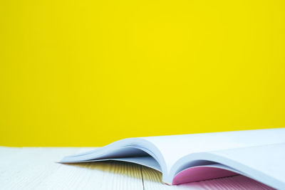 Close-up of book on table against yellow background