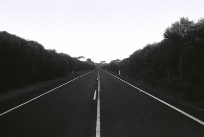 Empty road along trees
